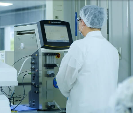 A man in a lab looking at a machine.